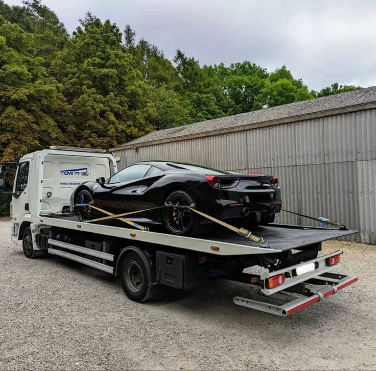 Voiture de sport sanglée sur le plateau avant transport