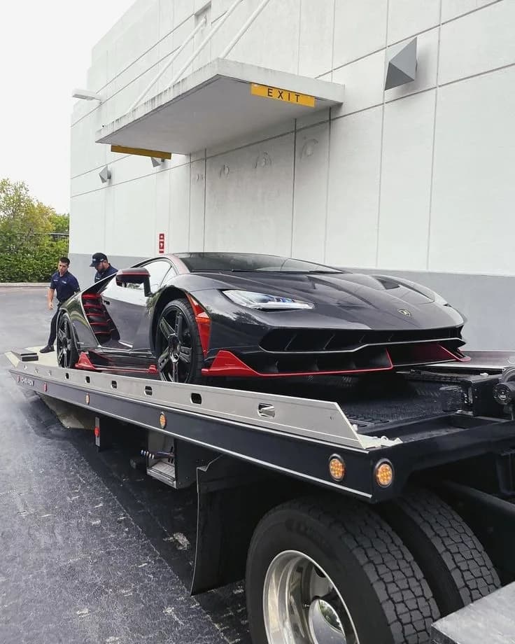 Chargement d’une supercar sur le plateau par deux opérateurs